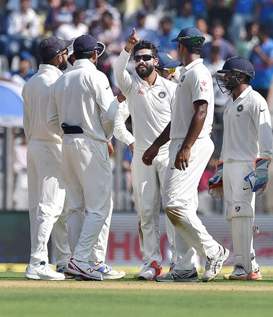 Indian players celebrate the wicket of England batsman Alastair Cook