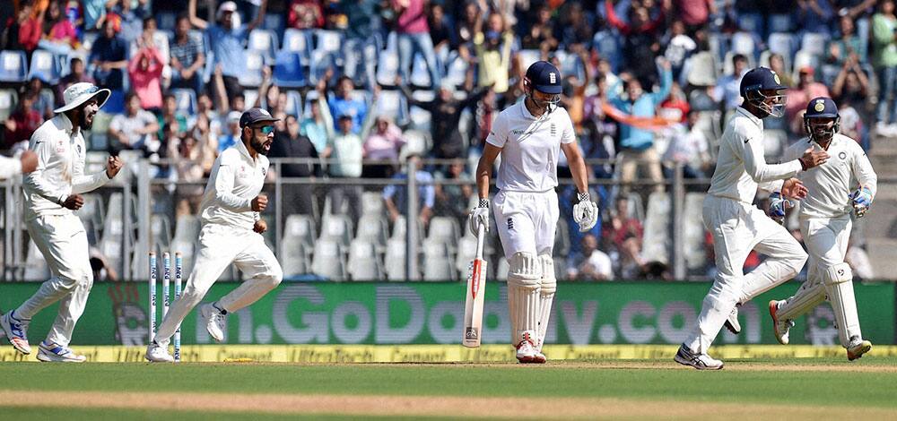 Indian players celebrate the wicket of England batsman Alastair Cook on the first day of the fourth Test match against England in Mumbai