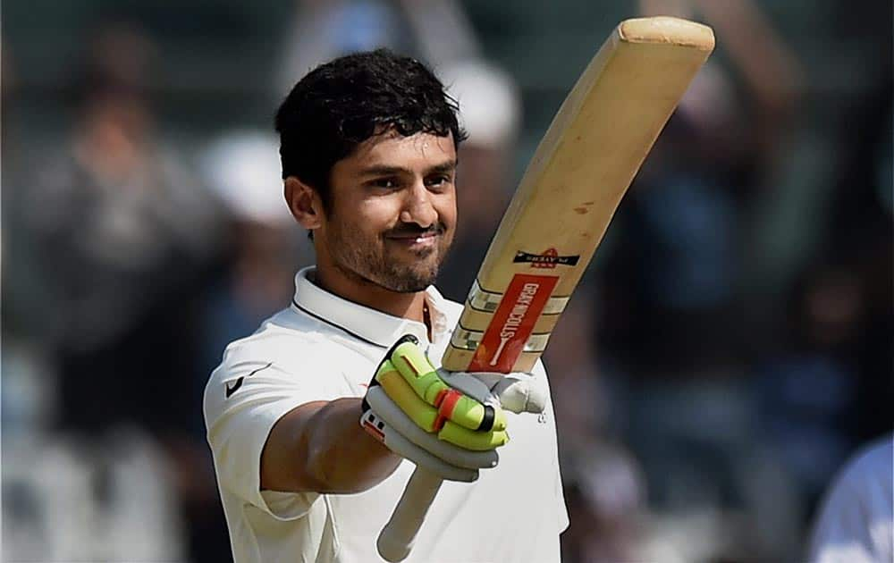 Karun Nair raises his bat after scoring his maiden century in an international match