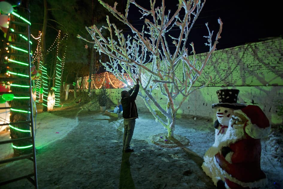 A man decorates a tree for Christmas