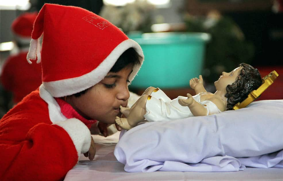 A boy kisses the feet of baby Jesus