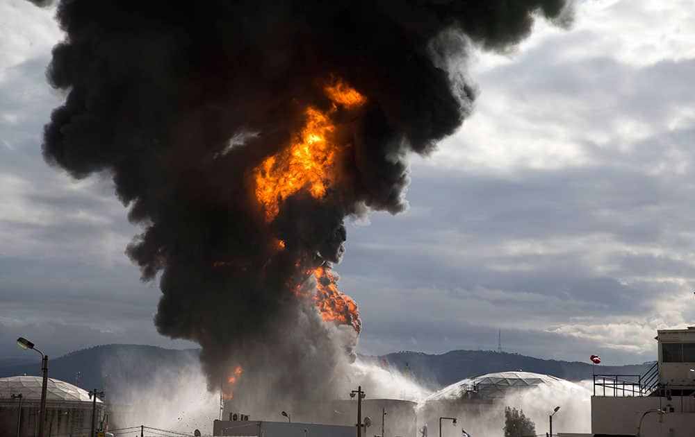 Fire fighters fight flames in a fuel tank in Oil Refineries Ltd 