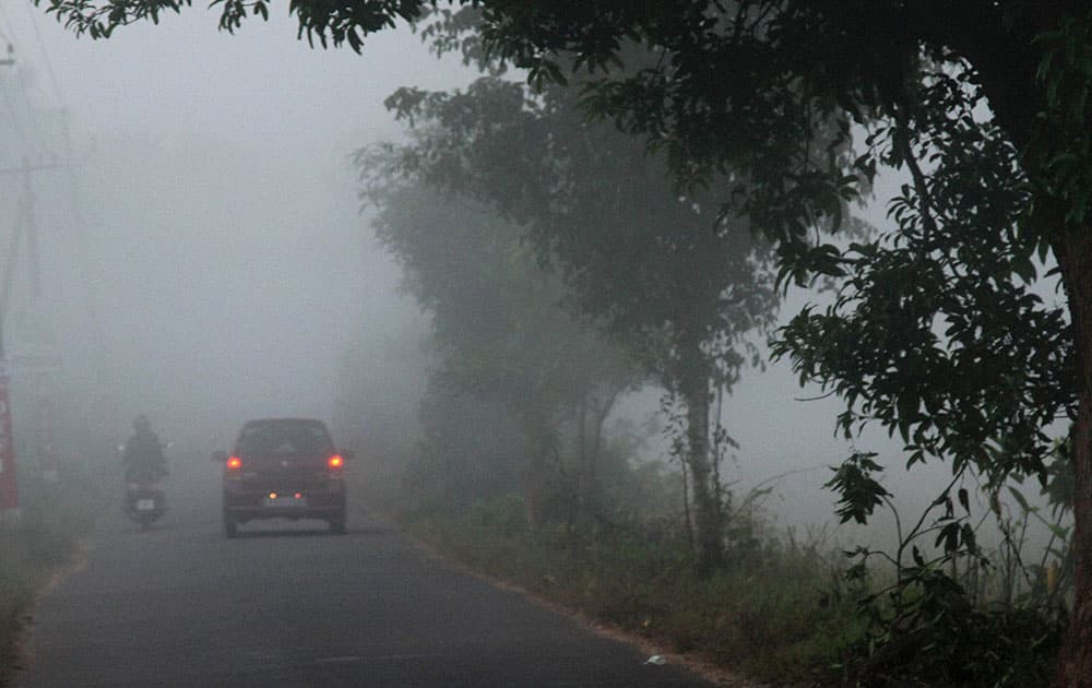 A vehicle moves in fog in Kozhikode