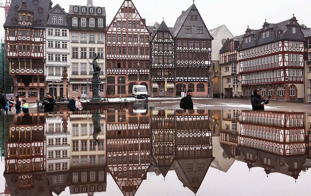 The timber-frame houses at the Roemerberg square are reflected in water