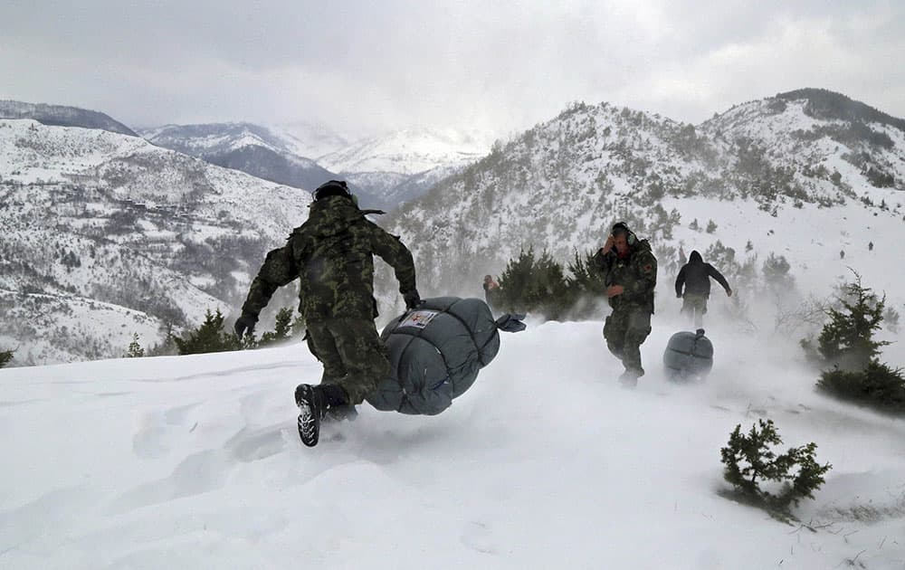 Military officers carry supplies for local residents