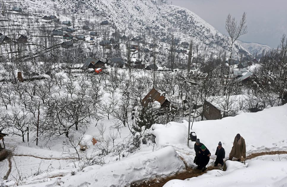 People walk through the snow on the out skirts of Srinagar.