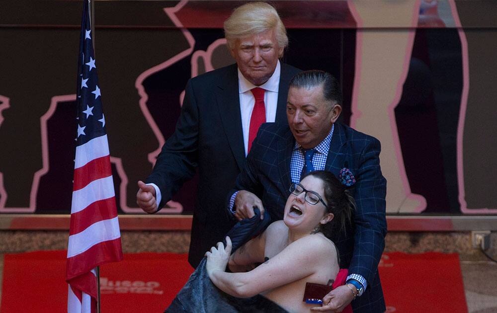 A woman makes a semi-naked protest during the inauguration of a figure Trump