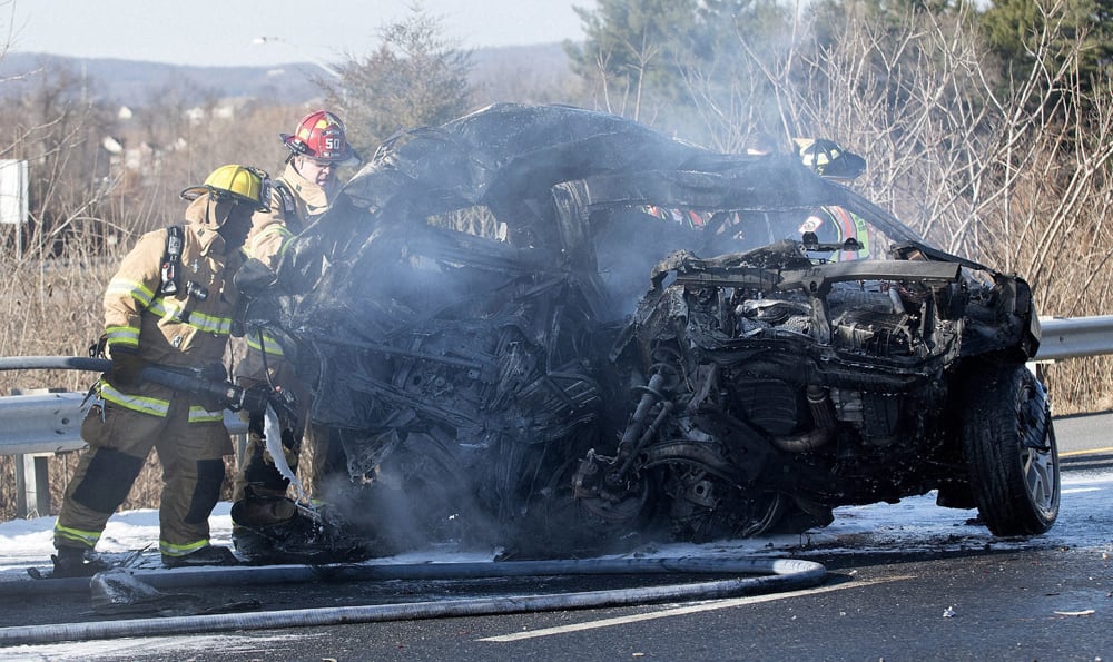 Firefighters extinguish a car