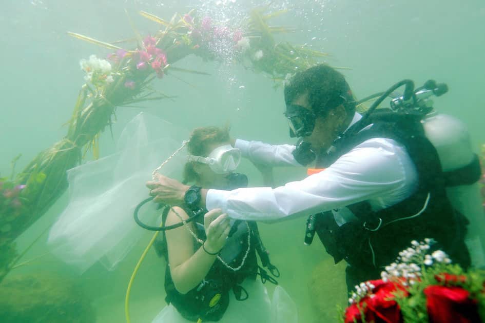 Couple exchanging wedding vows under sea