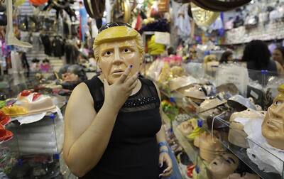 A woman trying on a mask of President Donald Trump