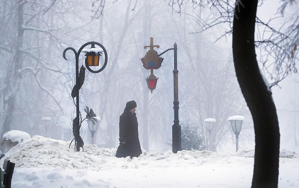 A woman walks through a snowy park in Minsk A woman walks through a snowy park in Minsk