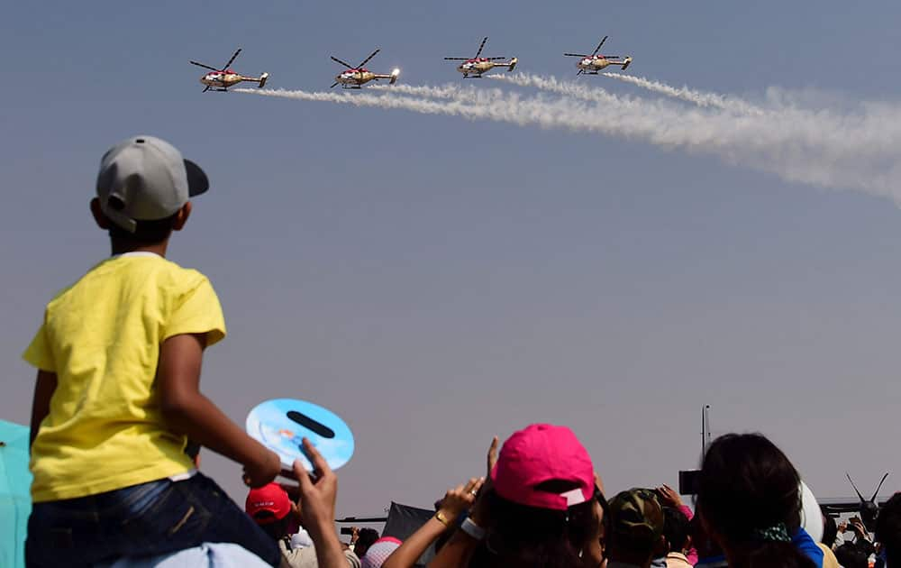 Indian Air Forces helicopter aerobatic team Sarang performs during the fourth day of the 11th biennial edition of AERO INDIA 2017