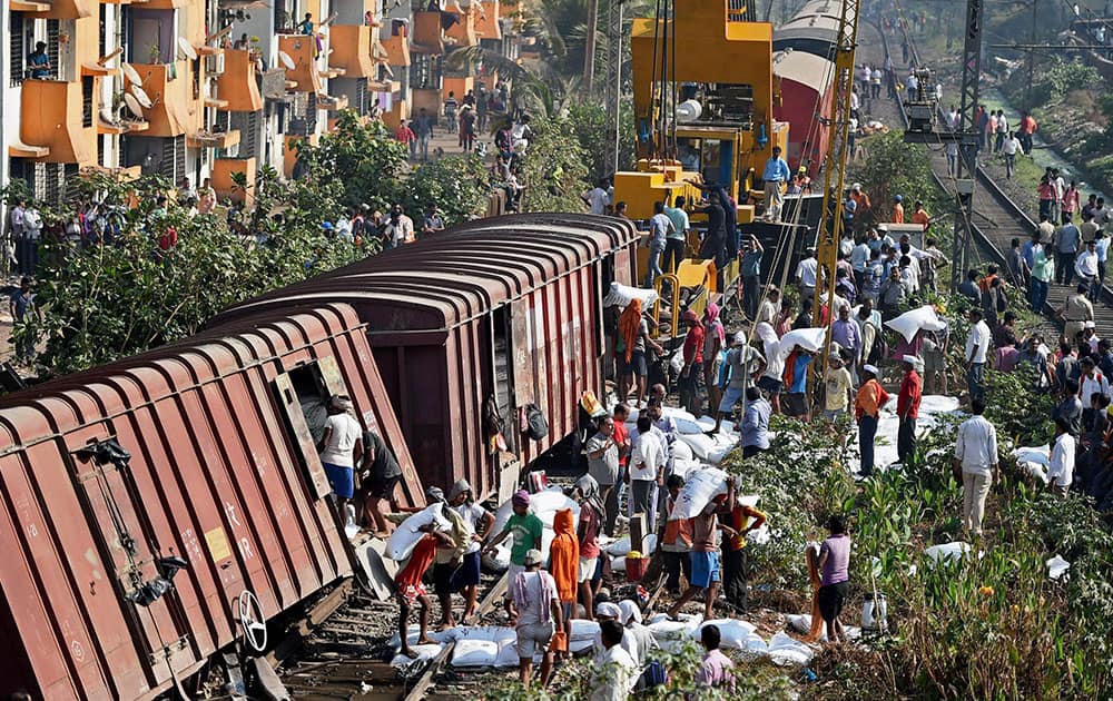 People unload cargo from a goods train that derailed on the harbour line near Guru Tegh Bahudur station in Mumbai