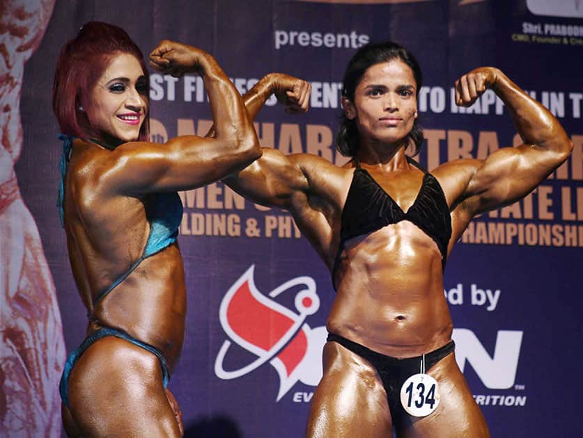 Women participants at a state-level body building championship flex their muscles in Thane