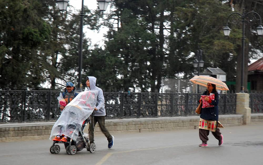 People walk on the Mall Road after it rained in Shimla