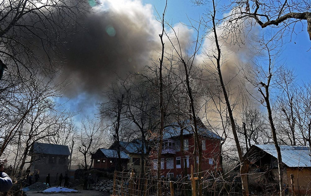 Smoke coming out of a residential house held by militants during an encounter with army