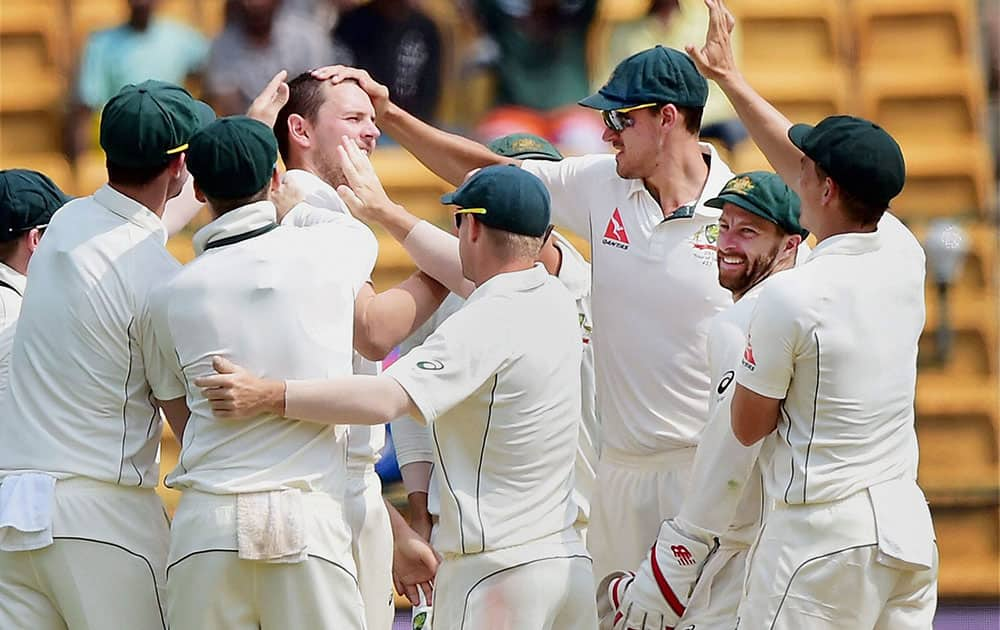 Josh Hazelwood with team mates celebrates the wicket of Virat Kohli