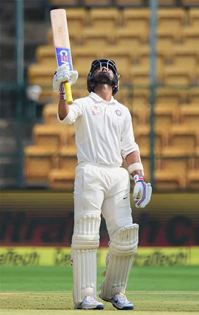 Ajinkya Rahane raises his bat after hitting a half century during the fourth day of the second test match between India and Australia
