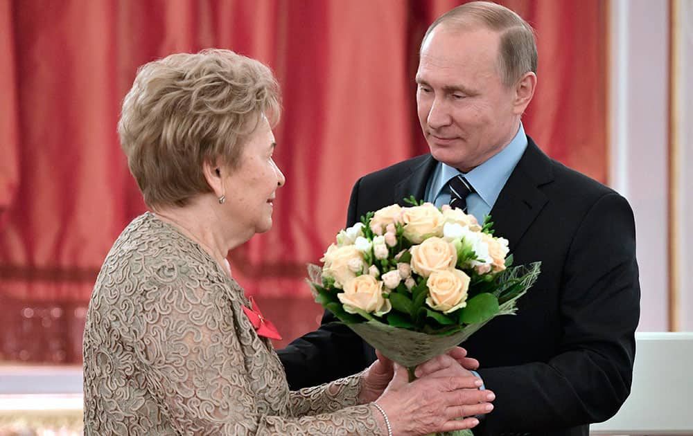 Vladimir Putin gives flowers to Naina Yeltsin at a reception marking her 85th birthday