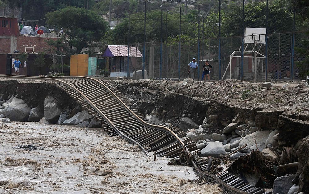 Train tracks lay destroyed in a flooded river in the Chosica district of Lima