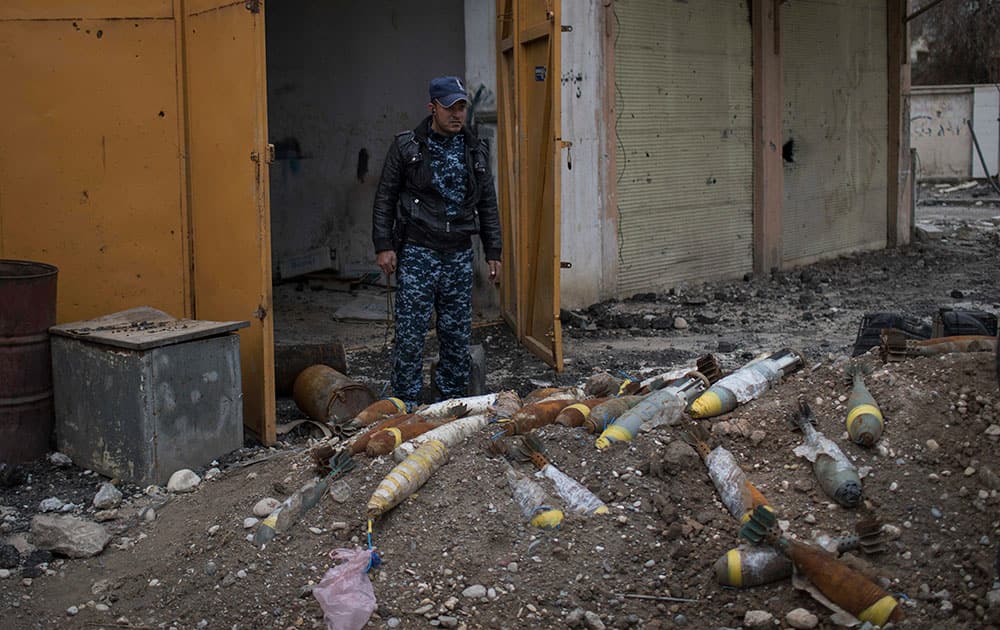 A Federal Police stands next to unexploded bombs left by Islamic State militants