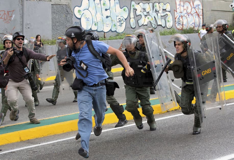 Venezuelan National Guard soldiers chase