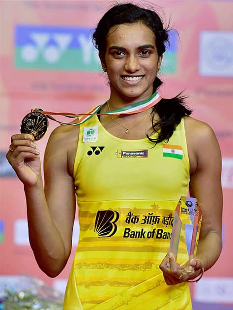 P V Sindhu is all smiles as she poses with her medal and trophy