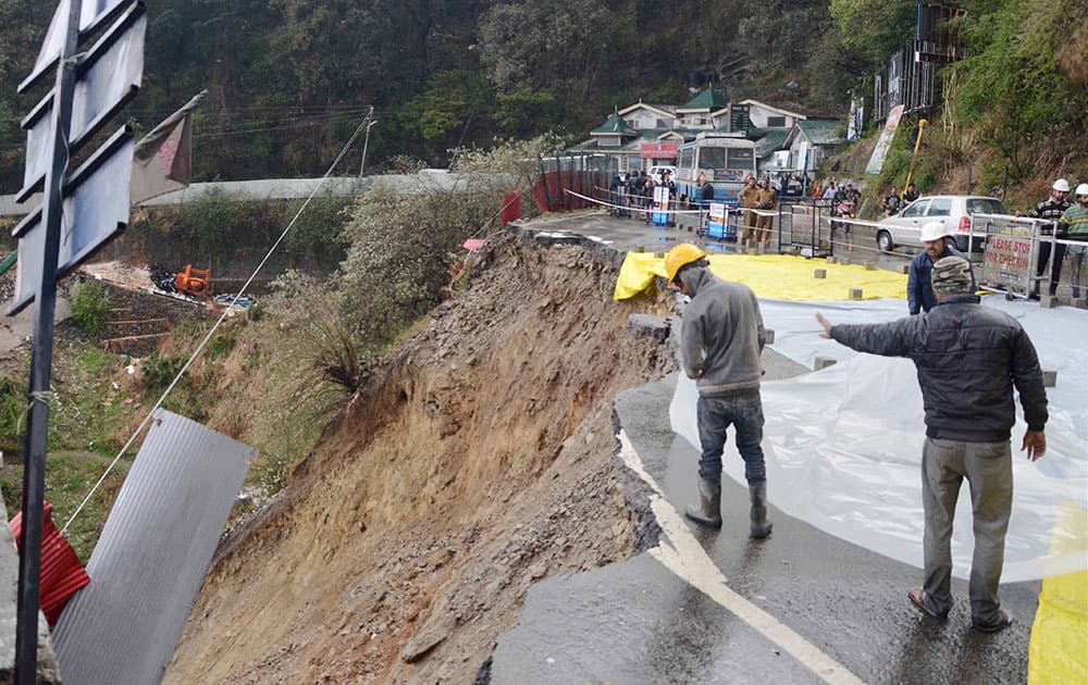 A damaged road after landslide due to heavy rains in Shimla