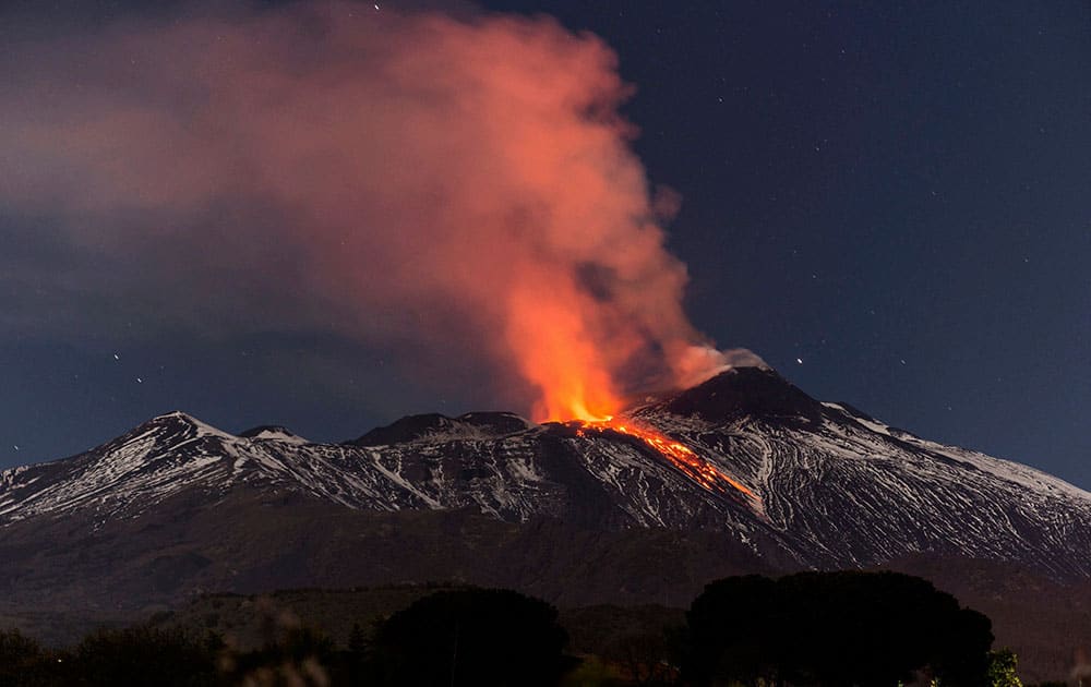 Snow-covered Mount Etna spews lava during an eruption