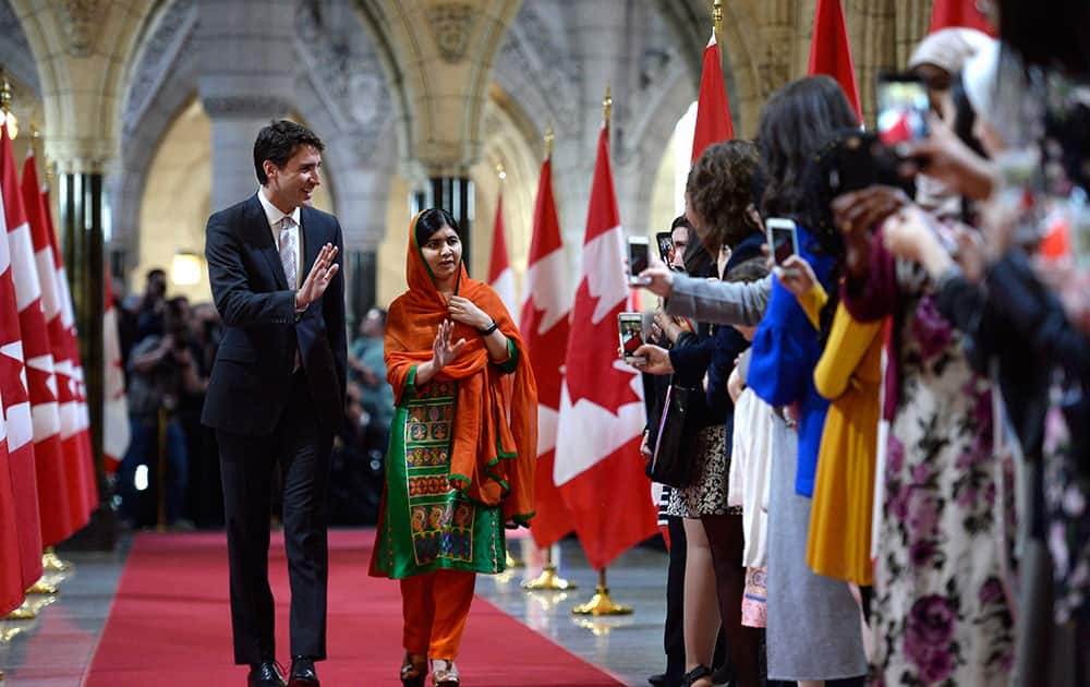 Malala Yousafzai walks through the hall of honour with PM Justin Trudeau