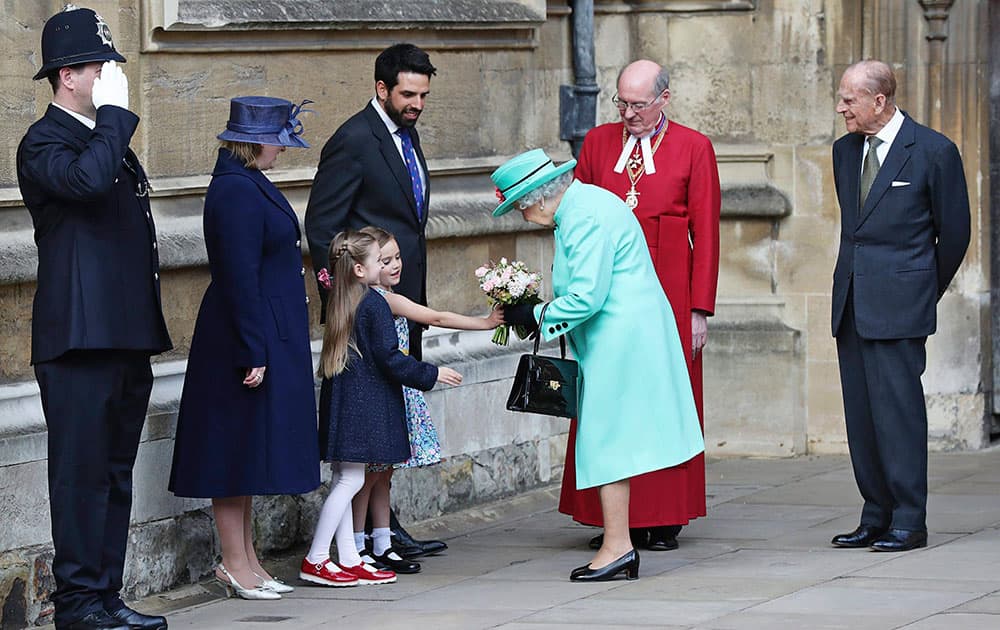 Britains Queen Elizabeth receives flowers as she leaves after attending the Easter Sunday