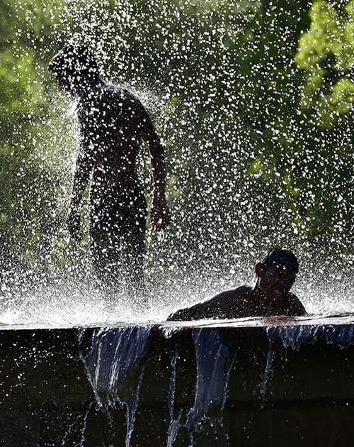 Youngsters splash water at a fountain