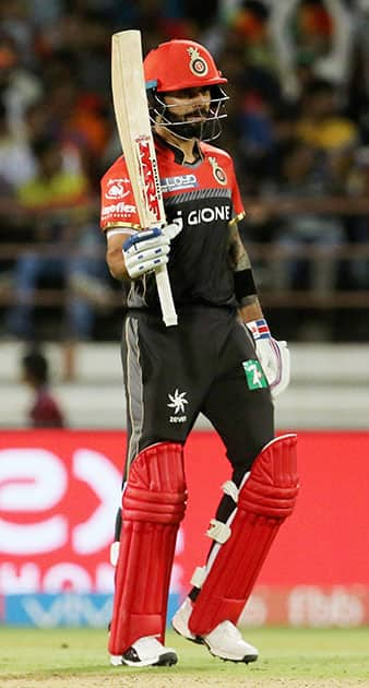 Virat Kohli raises his bat after scoring a fifty during an IPL 2017