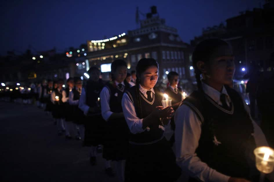 Nepalese students hold lighted candles