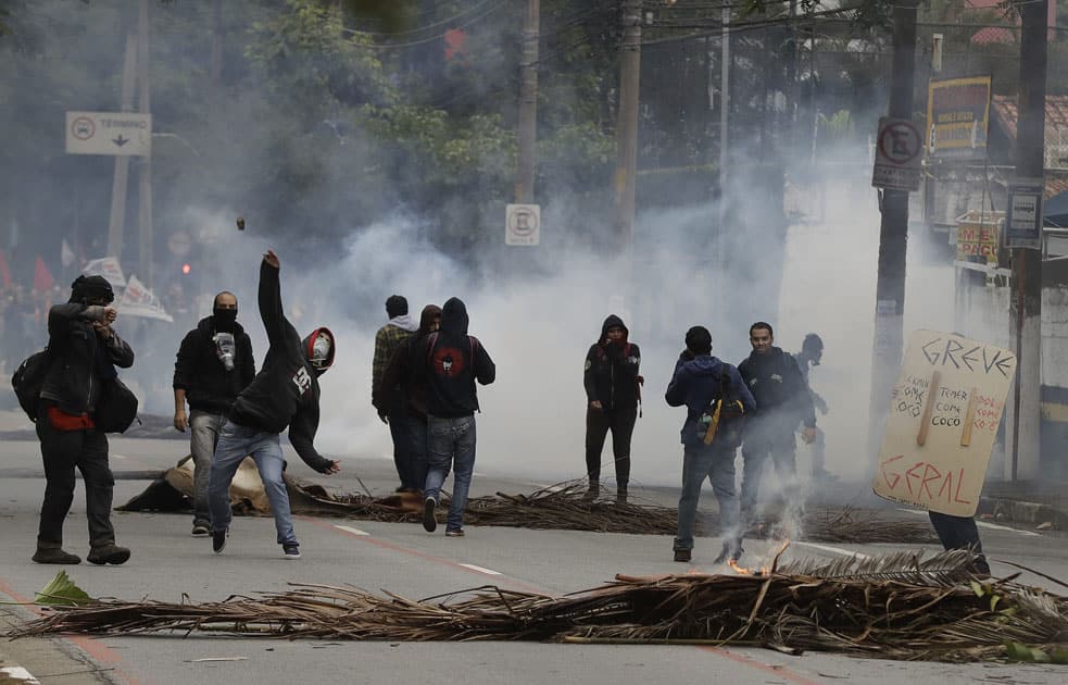 A demonstrator throws a stone