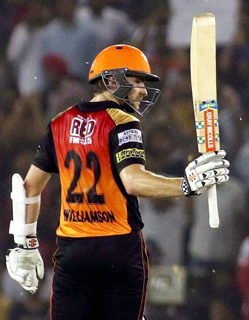 Kane Williamson raises his bat after scoring 50 runs