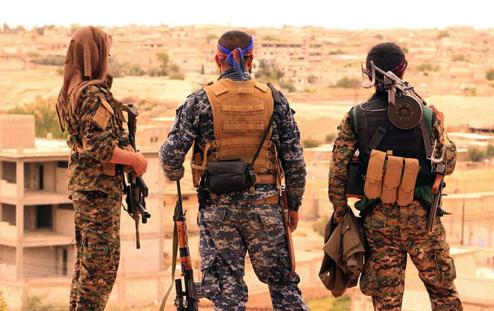 fighters from the SDF looking toward the northern town of Tabqa