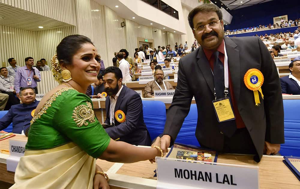 Best actress award winner Surabhi Jyoti exchanges greetings with Malyalam actor Mohan Lal at the 64th National Film Awards function