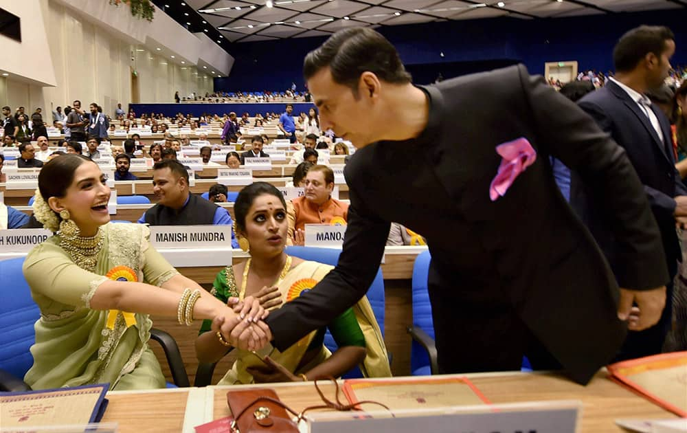 Best Actor award winner Akshay Kumar greets actress Sonam Kapoor as Best actress award winner Surabhi Jyoti looks on