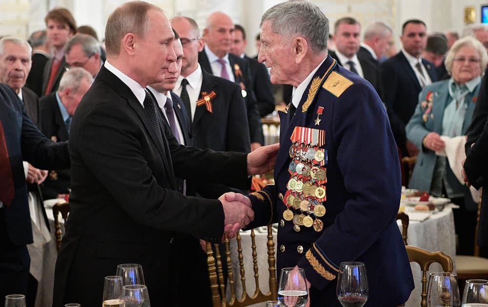 Russian President Vladimir Putin greets Sergei Kramarenko