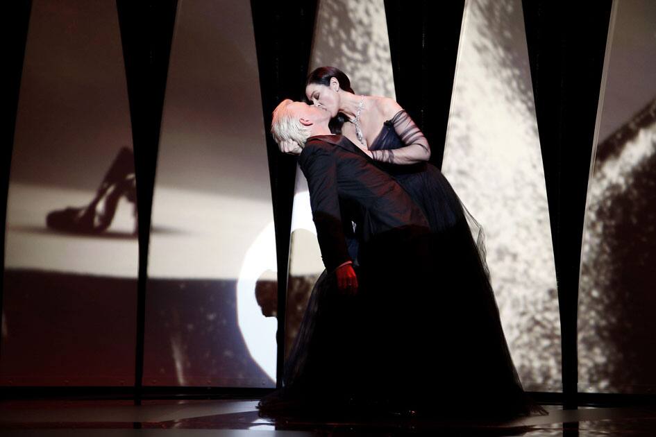 Ceremony host Monica Bellucci kisses actor Christian Lutz during the opening ceremony