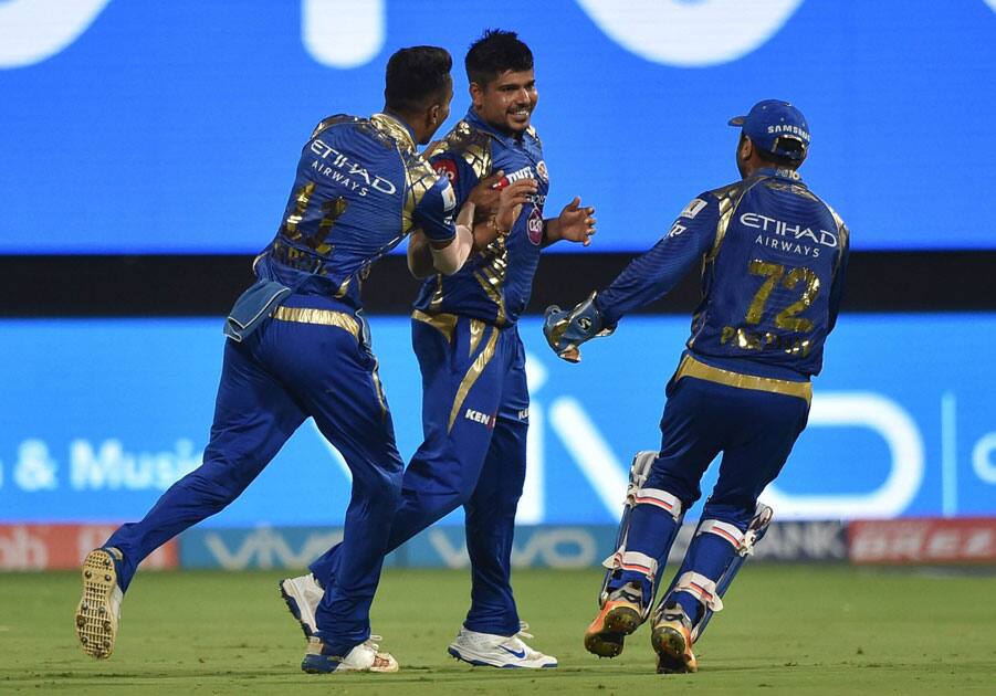 Karn Sharma with team mates celebrate the wicket of Colin De Grandhomme