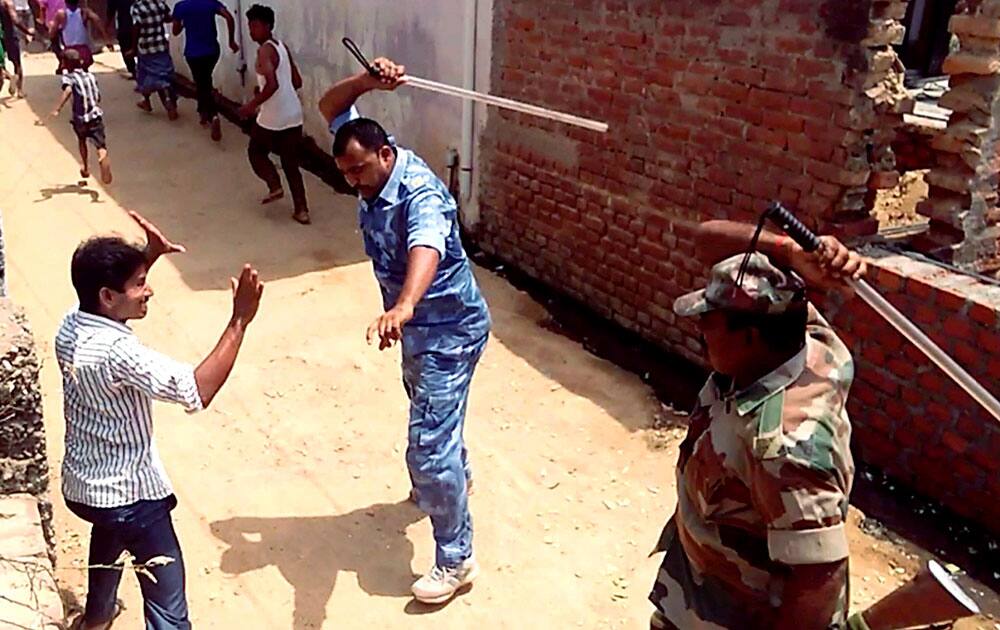 Police personnel baton charge during the two groups clash