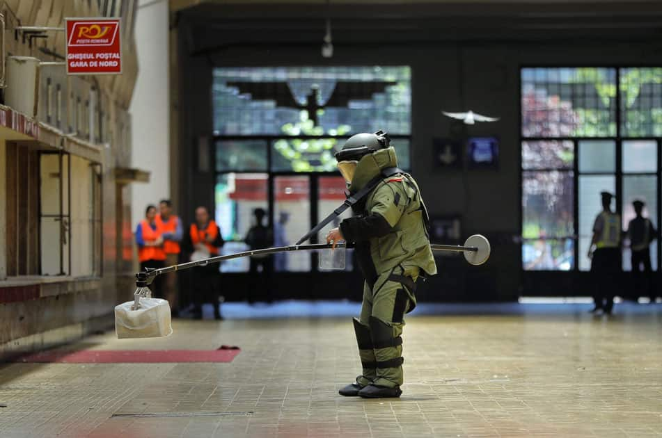 A Romanian explosives specialist handles a suspicious package