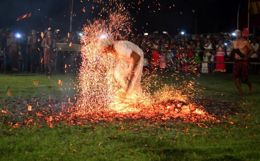 Priests belonging to the Rabha community run over burning charcoal