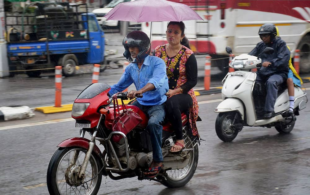 Bikers wade through as it rains in Guwahati