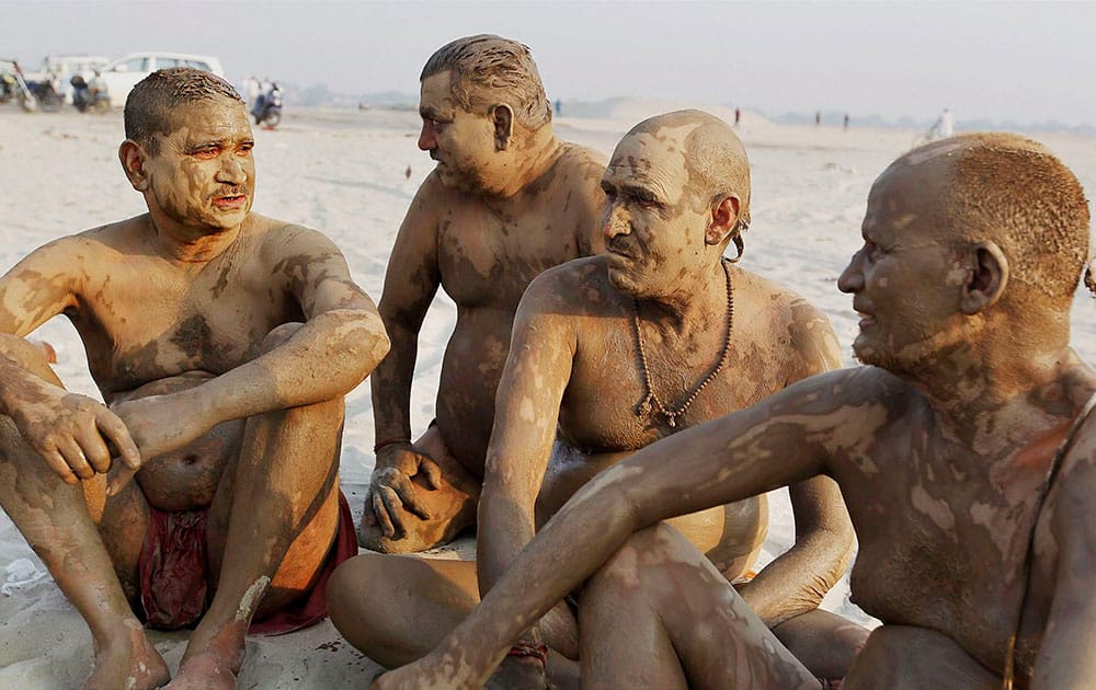 Men relaxing after applying mud on their bodies to cool themselves