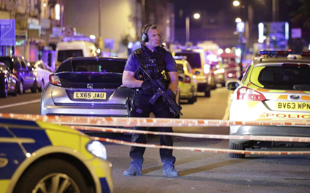 An armed police officer mans a cordon on the Seven Sisters Road