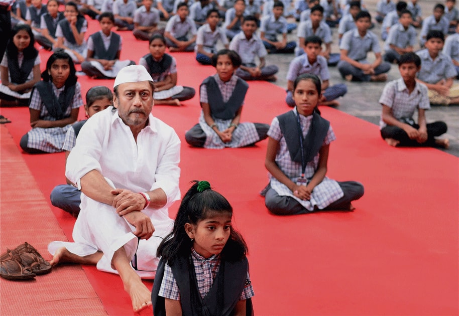 Bollywood actor Jackie Shroff along with children of farmers during a mass yoga event