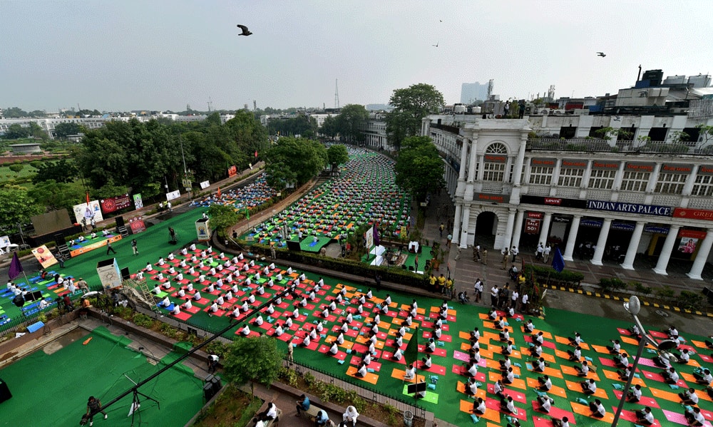 Yoga enthusiasts perform yoga at Connaught Place